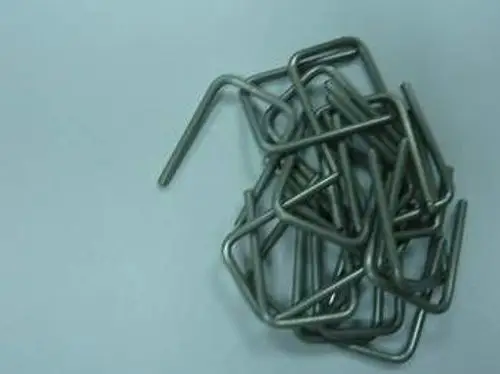 Stapel aus gebogenen Metallclips auf hellem Hintergrund, dargestellt in einer unordentlichen Anordnung. Die Clips sind von Remeha.